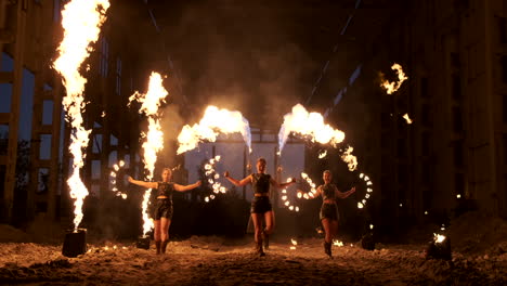Professional-fire-show-in-the-old-hangar-of-the-aircraft-show-professional-circus-artists-three-women-in-leather-suits-and-a-man-with-two-flamethrowers..